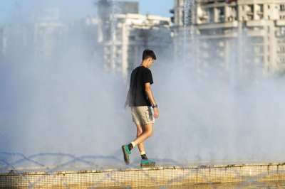 年轻男子 步行 喷泉 公园 随意的 盆地 水溅 喷射 城市景点