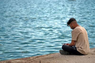 男孩 此人 年轻的 放置 湖岸边 听到的 音乐 耳机你的耳朵