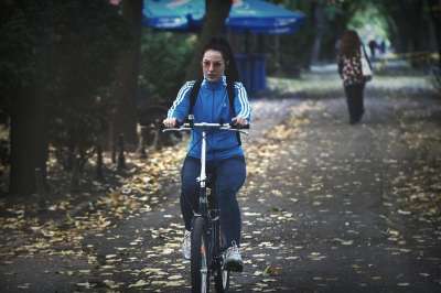 女士 骑自行车的人 骑自行车 晚上 胡同 公园 秋天 树叶 树木