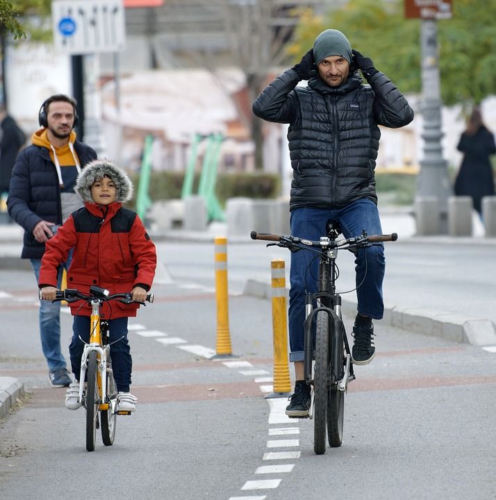 骑车人 骑术 自行车 街道 家庭 父亲 儿子